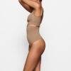 Nahtloser, hochtaillierter String-Tanga mit formgebendem Schnitt Nahtloser, hochtaillierter String-Tanga mit formgebendem Schnitt
